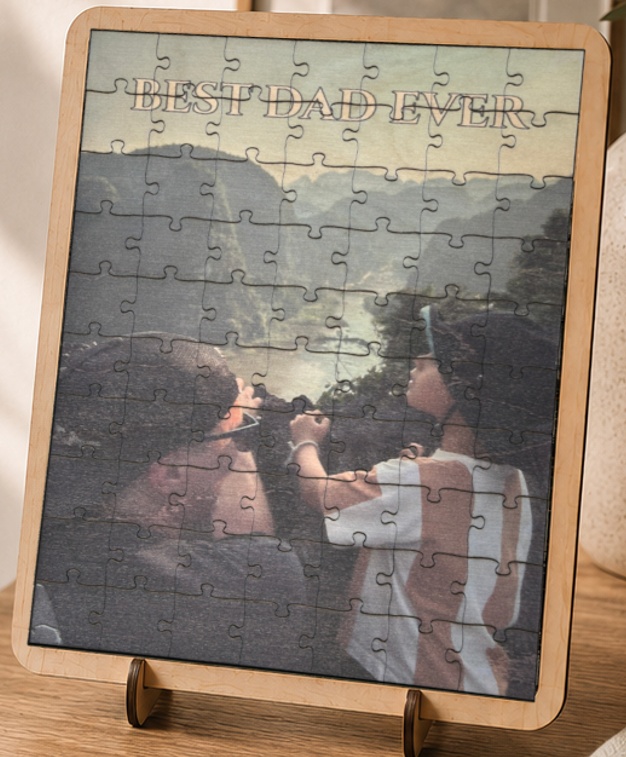 A finished photo puzzle standing on its display base, laser cut from wood with an engraved text border