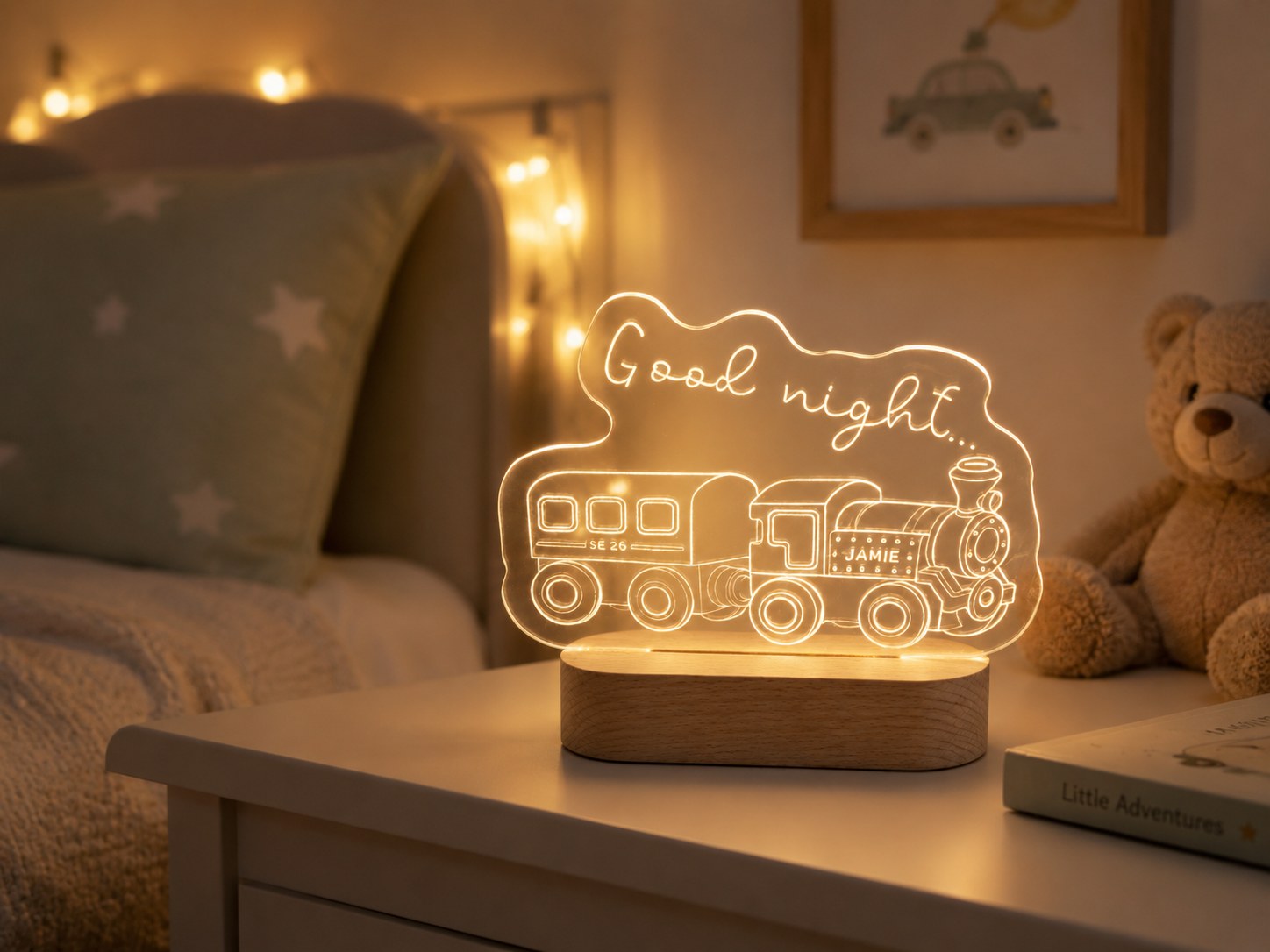 A finished train-themed night light lit up on a bedside table