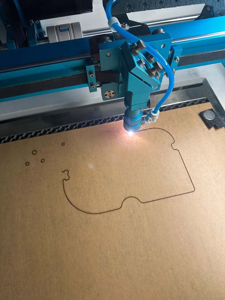 Our laser cutter mid-cut, tracing a custom design out of cardboard